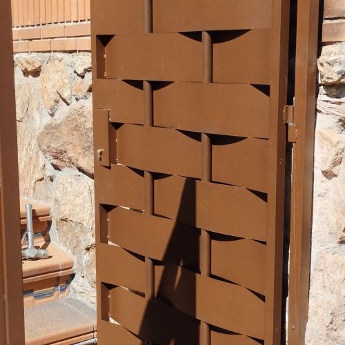 PUERTA DE HIERRO CON TUBOS VERTICALES Y CHAPA ENTRELAZADA